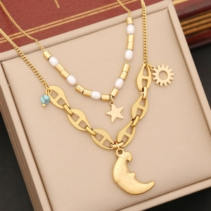 Double-layered gold necklace with moon and star pendants in a jewelry box