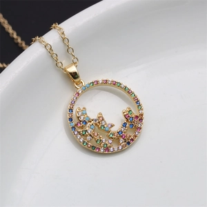 Macro shot of gold circular pendant with colorful gemstone plant pattern on ceramic