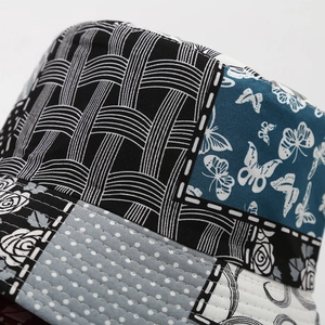 Dettaglio del cappello alla pescatora patchwork con stampe a farfalla e cuciture a contrasto