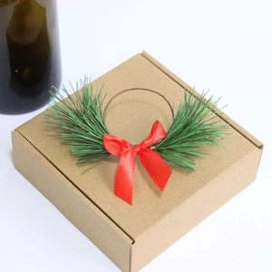Close-up of a Christmas pine needle napkin ring with red bow on a brown gift box