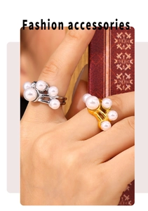 Detailopname van een gouden ring met parelcluster gedragen door een model bij een boek