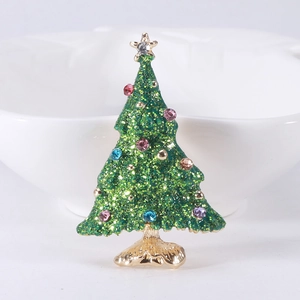 Detail of green enamel Christmas tree brooch with colorful rhinestones and gold finish