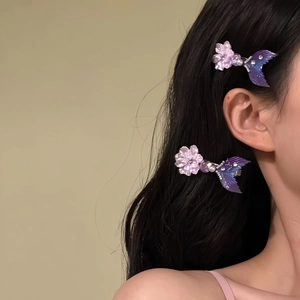 Side view of a model wearing purple mermaid tail hair clips with flower accents