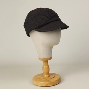Detail view of the linen newsboy cap featuring vintage overlapping pleats and texture