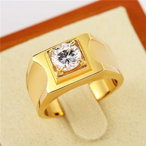 Gros plan d'une bague pour hommes plaquée or avec un grand oxyde de zirconium rond serti griffes