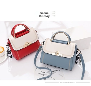 Detail of color-block leather handbags with metal ring locks and cute bear pendants