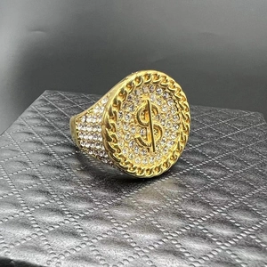 Macro view of gold-plated hip hop ring with dollar sign and micro-paved rhinestones