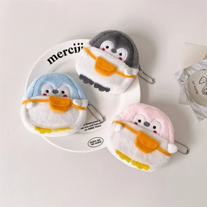 Detail view of plush penguin coin purses in blue, grey, and pink with metal chains