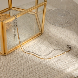 Detail of two-tone gold and silver snake chain bracelet with lobster clasp and extender