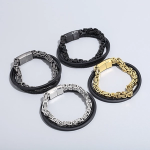 Detail von mehrlagigen Herrenarmbändern aus geflochtenem Leder und Edelstahlketten