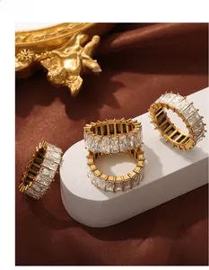 Detail of four gold-plated eternity rings set with sparkling rectangular zircon stones