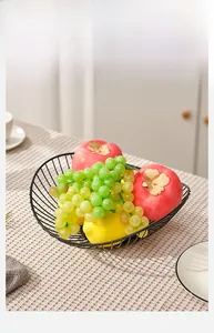 Detail of black iron fruit basket with a modern wire hollow design for kitchen storage