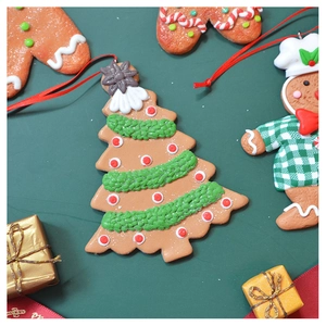 Close-up of clay gingerbread man and Christmas tree ornaments with festive matte texture
