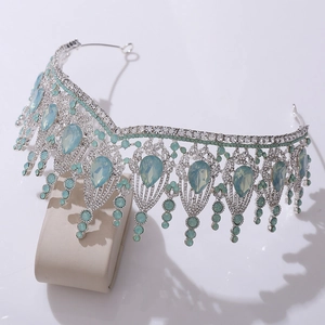 Detailed close-up of Baroque silver tiara with light blue crystals and shimmering rhinestones