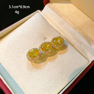 Macro detail of a gold brooch with yellow gemstones and zircons, size 3.1cm x 0.9cm