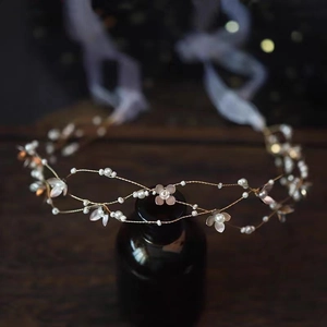 Elegant gold bridal headband with white flowers, pearls, and a ribbon tie for weddings