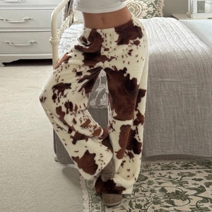 Détail du tissu en polaire épaisse à motif vache et de la coupe ample de ce pantalon