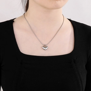 Collier avec pendentif cœur argenté et chaîne serpent porté par un mannequin