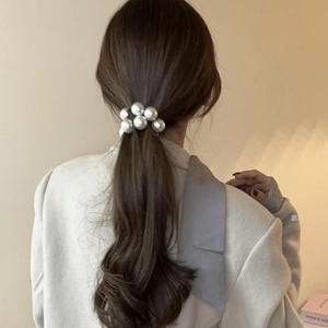 Elegant artificial pearl hair tie worn on a low ponytail hair style for women