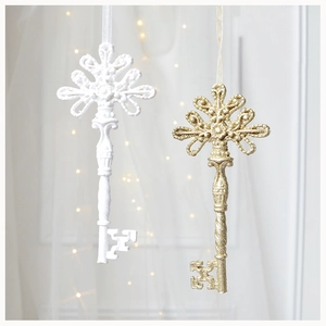 Detail of resin Christmas key ornaments with white matte and gold glitter finishes