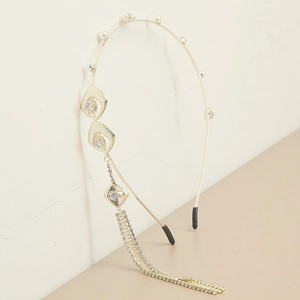 Detail of golden metal headband with sparkling rhinestone tassels and elegant pearls