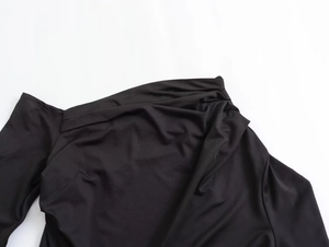 Detailed close-up of the elegant pleated neckline on a black asymmetrical maxi dress
