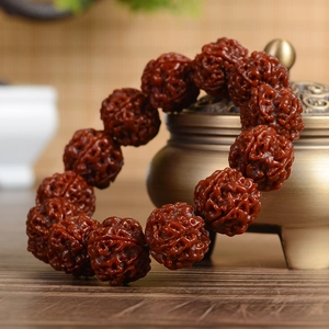 Rudraksha seed bracelet on antique bronze incense burner with warm wooden background