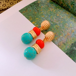 Detail view of vintage round turquoise and orange beaded earrings with gold metal accents