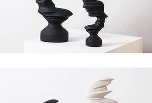 Detailed view of abstract ceramic person statues in matte black and off-white finish