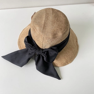 Dettaglio del cappello da sole che mostra la trama intrecciata e l'elegante fiocco nero