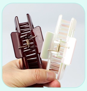 Detailed view of medium square claw clips in dark brown and pearlescent white finish