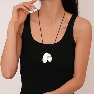 Close-up of double silver irregular oval pendants on a sleek black cord necklace