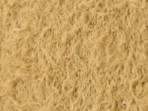 Macro detail of tan curly faux fur texture and synthetic fibers on a knit sweater