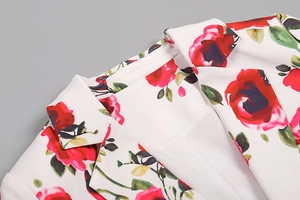 Détail du revers et de l'épaule du blazer avec motif floral de roses rouges