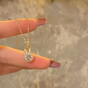 Vue macro du pendentif lapin doré avec des strass étincelants pour les femmes