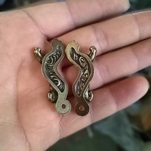 Detailed close-up of vintage bronze tiger seal charms with ornate relief engravings