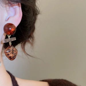 Gros plan de boucles d'oreilles rétro en bois avec perles d'ambre et motifs léopard