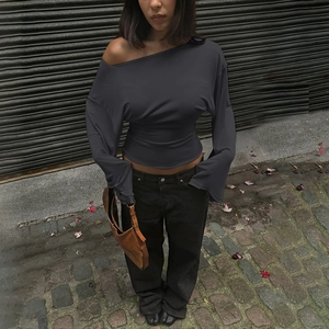 Detail view of charcoal grey slim fit long sleeve top with off-shoulder V-neck design