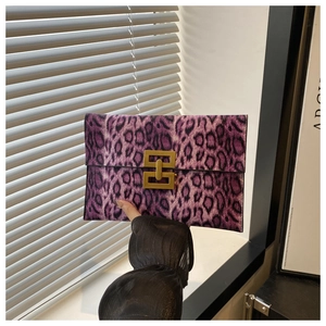 Detail of purple leopard envelope clutch featuring a gold geometric interlocking metal lock