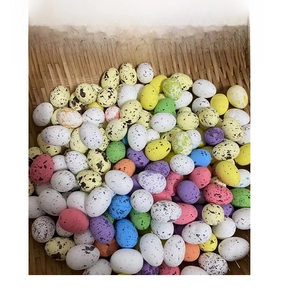 Détail de mini œufs de Pâques colorés et tachetés dans un panier en bambou rustique