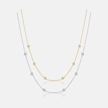 Vertical view of gold and silver plated necklaces with clear round gemstones and reflections