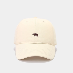 Detailopname van beige katoenen honkbalpet met klein beertje borduursel