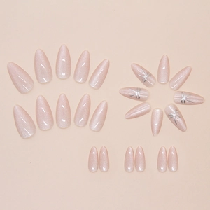 Detail of almond press-on nails with pink cat eye effect and silver ribbon bows
