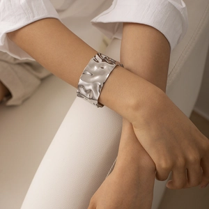 Detailed view of wide silver hammer textured cuff bracelet with lava irregular finish