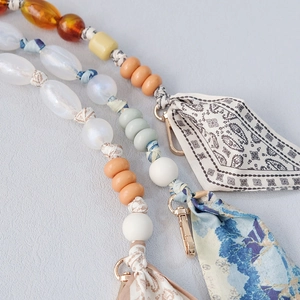 Detail of silk scarf chain strap with pearl beads and golden lobster clasp closure