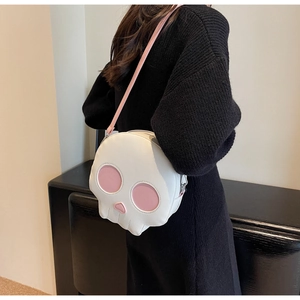 Detail view of funny skull crossbody bag in white and pink faux leather on model back