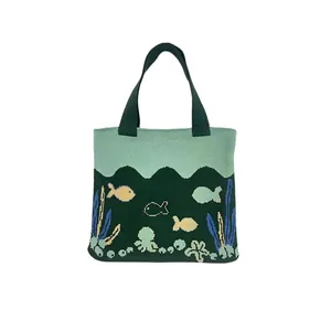 Detail of green knitted tote bag featuring colorful ocean octopus and fish patterns