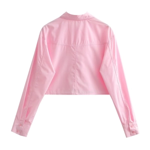 Vue arrière de la chemise courte rose vif montrant les plis au dos et le coton lisse