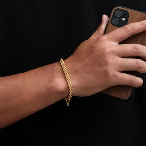 Detail view of the twisted gold chain bracelet featuring elegant metallic textures
