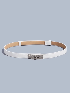 Macro detail of white cross-grain leather belt with sparkling rhinestone Kelly lock buckle